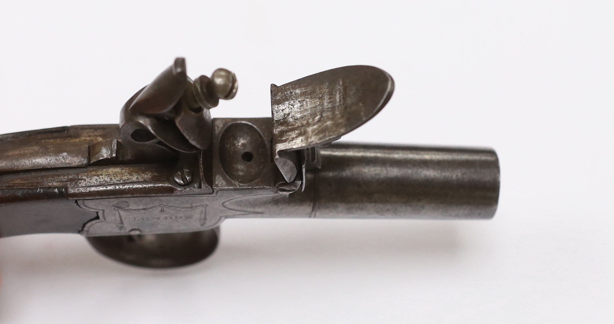 A small boxlock flintlock pistol by Perkins of London, with turn-off barrel, frame signed by the maker, with walnut slab grip, barrel 4.5cm